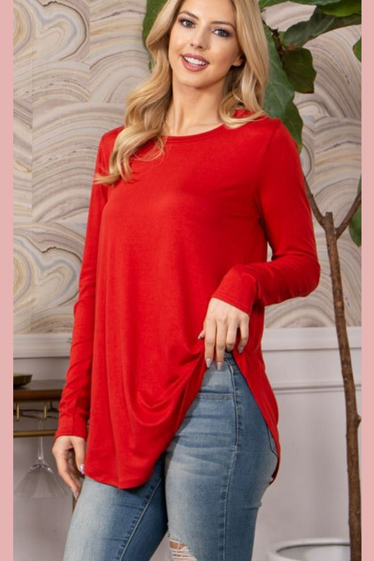Rust colored lightweight long sleeve top with rounded hem. 